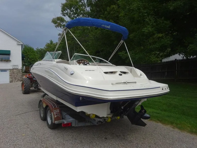 Slide: The Image of 2004 Sea Ray 220 Sundeck boat on trailer with blue canopy in driveway. - 6