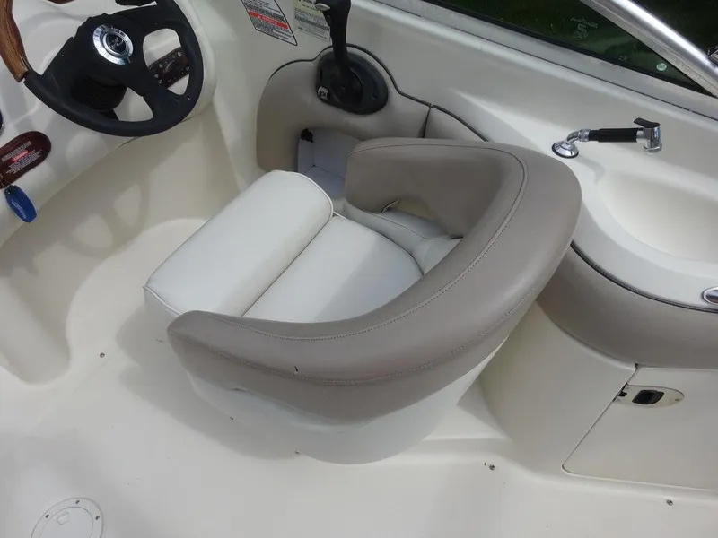 Slide: The Image of 2004 Sea Ray 220 Sundeck helm with beige seating and steering wheel. - 8