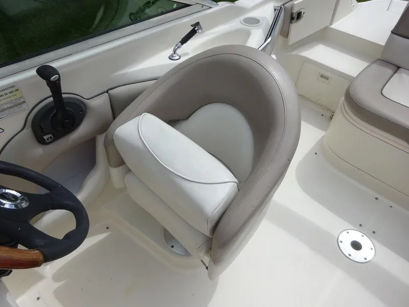 Slide: The Image of 2004 Sea Ray 220 Sundeck boat interior with steering wheel and seating. - 9