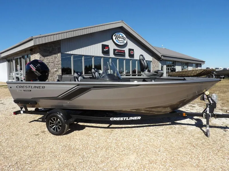 The Image of 2025 Crestliner 1750 Hawk Side Console boat on trailer, parked outside dealership. - 1