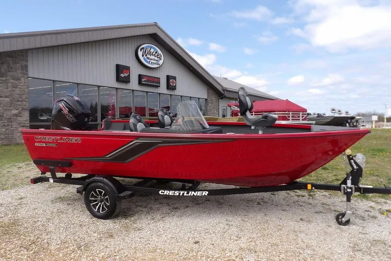 Slide: The Image of 2025 Crestliner 1750 Fish Hawk SC boat in vibrant red, parked outside a marine center. - 49