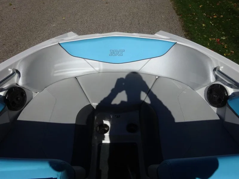 Slide: The Image of 2019 MasterCraft NXT20 boat interior with blue and gray seating, shadow visible. - 15