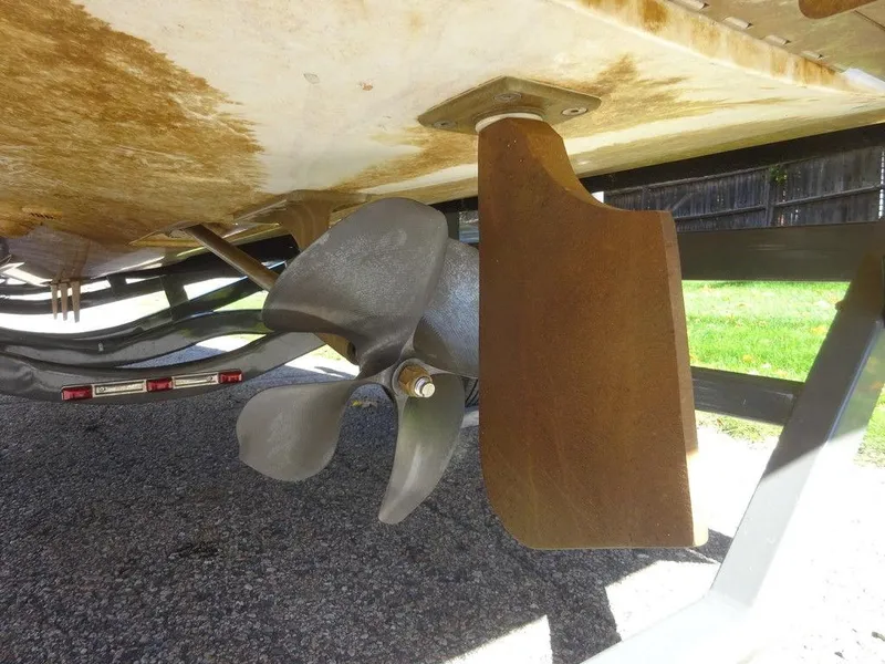 Slide: The Image of 2019 MasterCraft NXT20 boat propeller and rudder detail, showing wear and rust. - 18