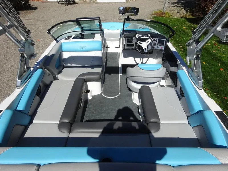 Slide: The Image of 2019 MasterCraft NXT20 boat interior with blue and gray seating, steering wheel, and open deck layout. - 7