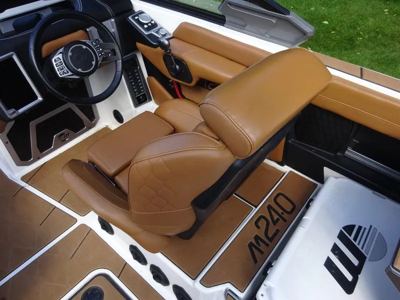 Slide: The Image of 2020 Malibu M240 boat interior with tan leather seats and modern dashboard. - 10