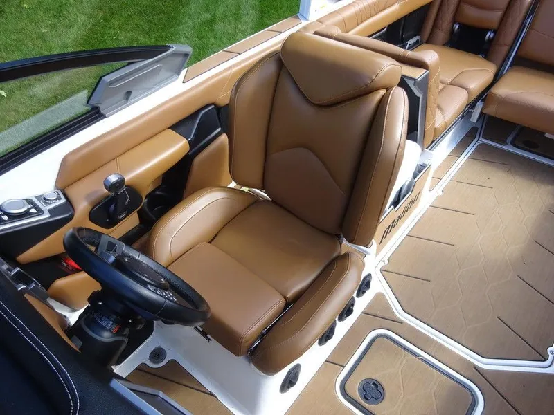 Slide: The Image of 2020 Malibu M240 boat interior with brown leather seats and modern dashboard. - 11