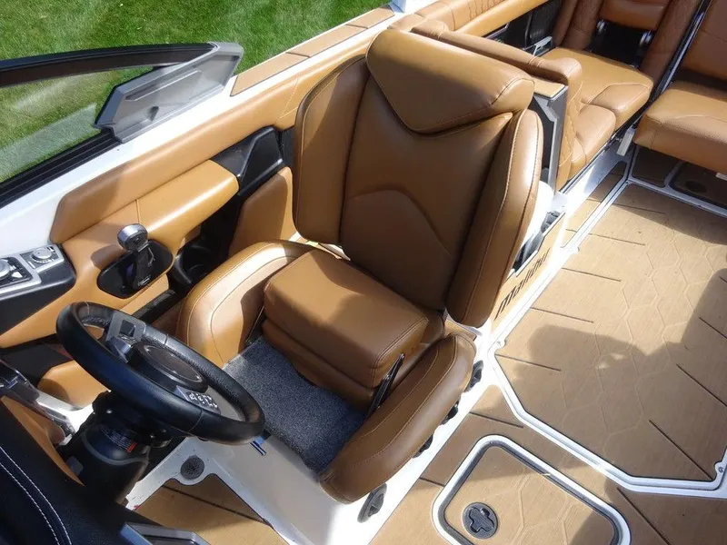 Slide: The Image of 2020 Malibu M240 boat interior with tan leather seats and modern steering wheel. - 12
