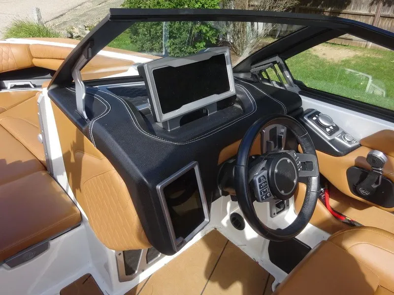 Slide: The Image of 2020 Malibu M240 boat interior with tan leather seats and modern dashboard controls. - 15