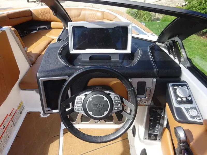Slide: The Image of 2020 Malibu M240 boat dashboard with touchscreen, steering wheel, and control panel. - 16