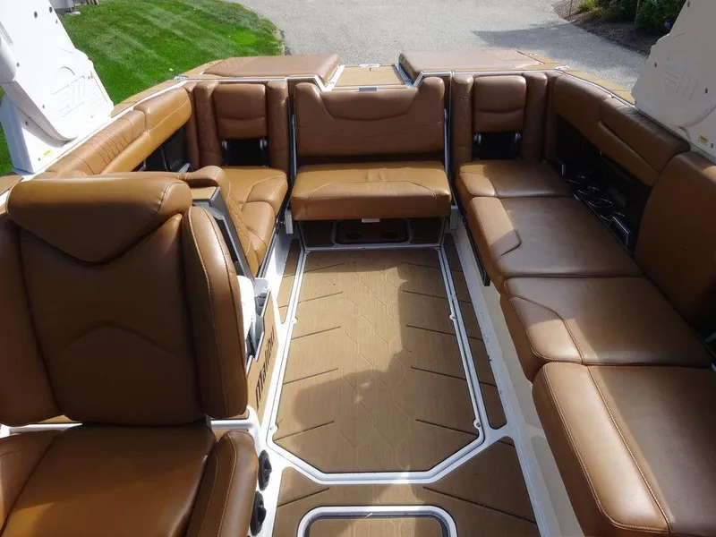 Slide: The Image of 2020 Malibu M240 boat interior with brown leather seating and spacious layout. - 18