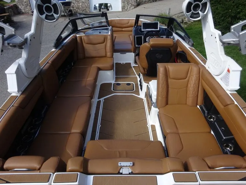 Slide: The Image of 2020 Malibu M240 boat interior with luxurious brown seating and modern dashboard. - 7