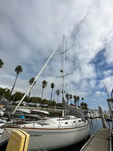 Slide: The Image of 1979 CAL 39 MK II Tall Rig sailboat docked in a marina, surrounded by other boats. - 5