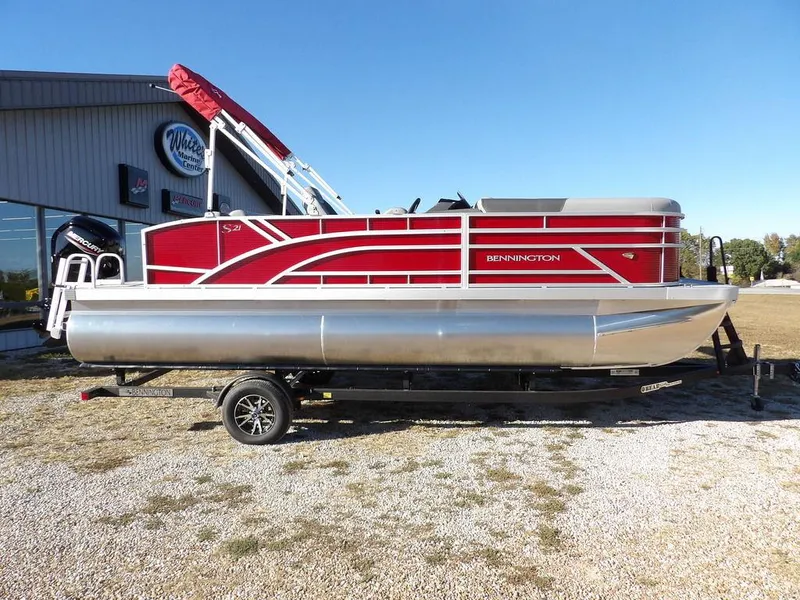 Slide: The Image of 2025 Bennington 21 SLJ pontoon boat with red accents on a trailer. - 1
