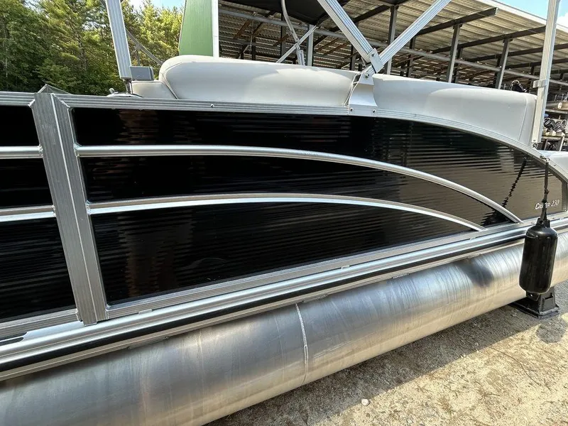 Slide: The Image of 2022 Harris Cruiser 230 pontoon boat with sleek black paneling and silver accents. - 12