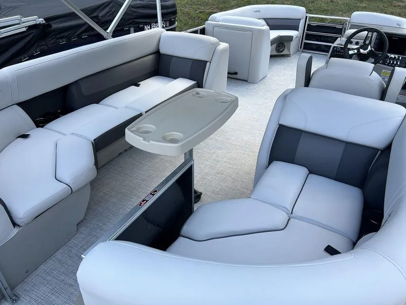 Slide: The Image of 2022 Harris Cruiser 230 pontoon boat interior with plush seating and table. - 4