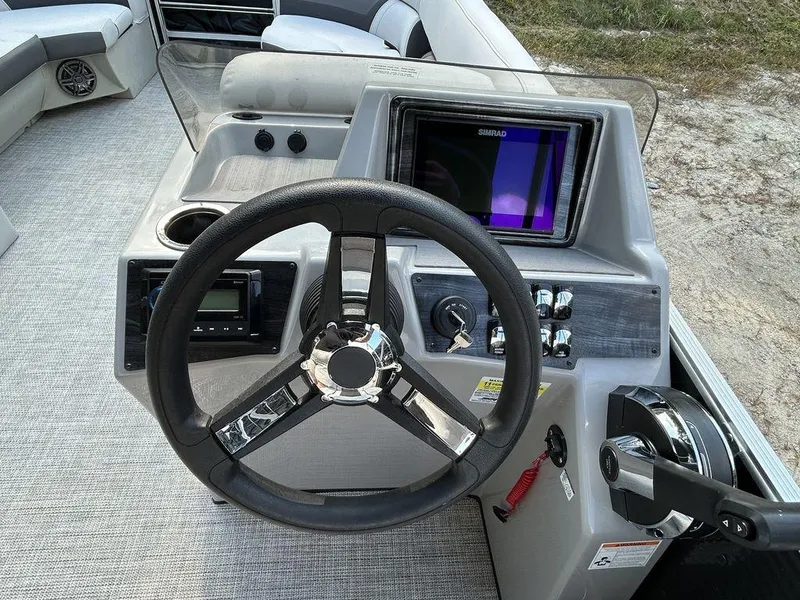 Slide: The Image of 2022 Harris Cruiser 230 boat dashboard with steering wheel and control panel. - 6