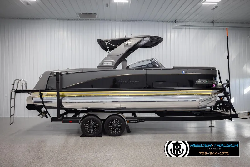 Slide: The Image of 2022 Avalon Waketoon boat on trailer in showroom, side view. - 2
