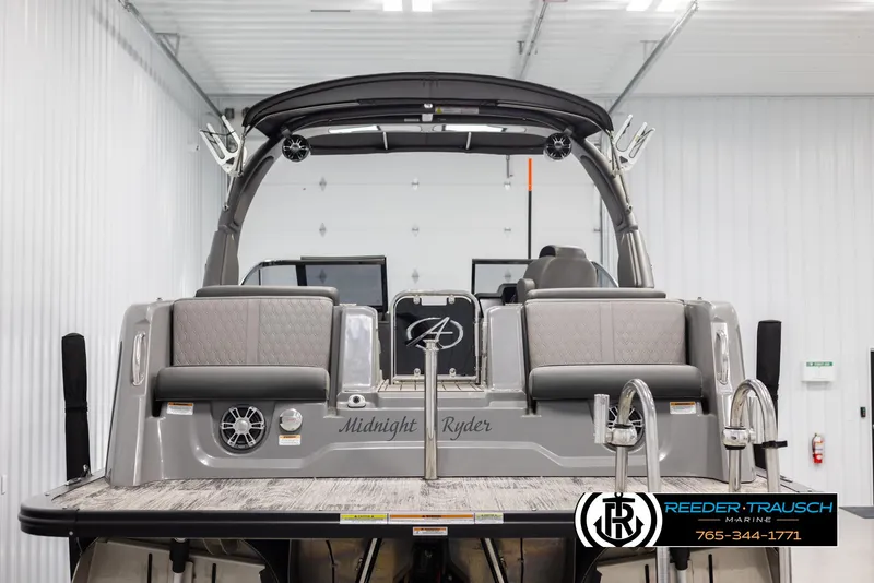 Slide: The Image of 2022 Avalon Waketoon boat, rear view in a showroom, featuring "Midnight Ryder" branding. - 4