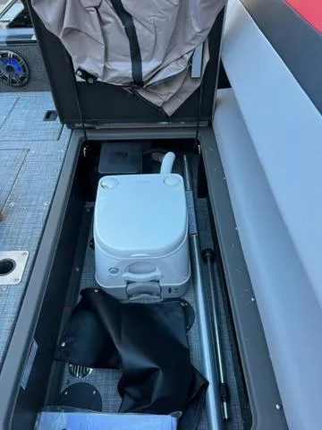 Slide: The Image of 2025 Princecraft Ventura 230 boat interior storage with portable toilet and accessories. - 8