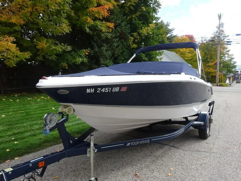 Slide: The Image of 2013 Four Winns Horizon 200 boat on trailer, parked on a tree-lined street. - 3