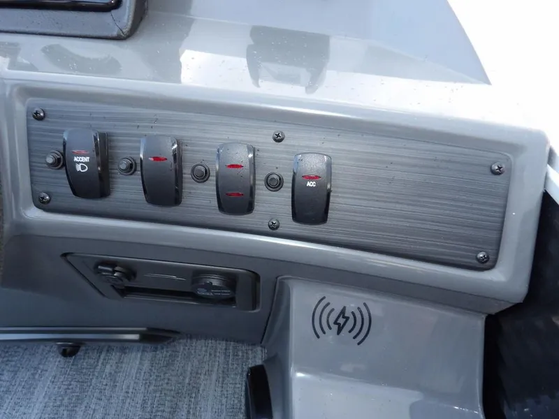 Slide: The Image of Control panel of 2025 Bennington 21 SL boat with switches and wireless charging pad. - 25