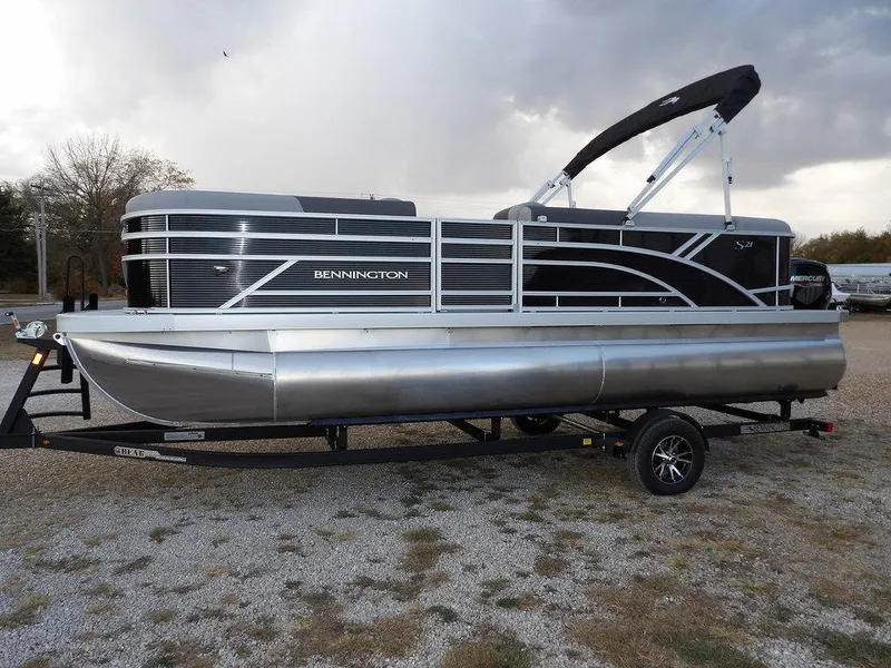 Slide: The Image of 2025 Bennington 21 SL pontoon boat on trailer, sleek design, outdoor setting. - 3