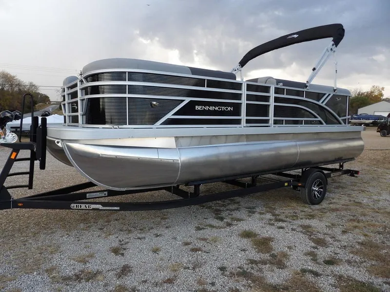 Slide: The Image of 2025 Bennington 21 SL pontoon boat on trailer, parked outdoors. - 4