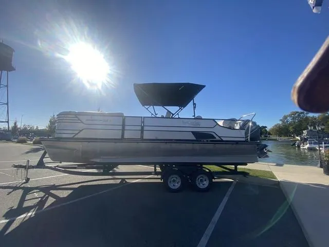 Slide: The Image of 2022 G3 SL pontoon boat on trailer under bright sun at marina. - 6
