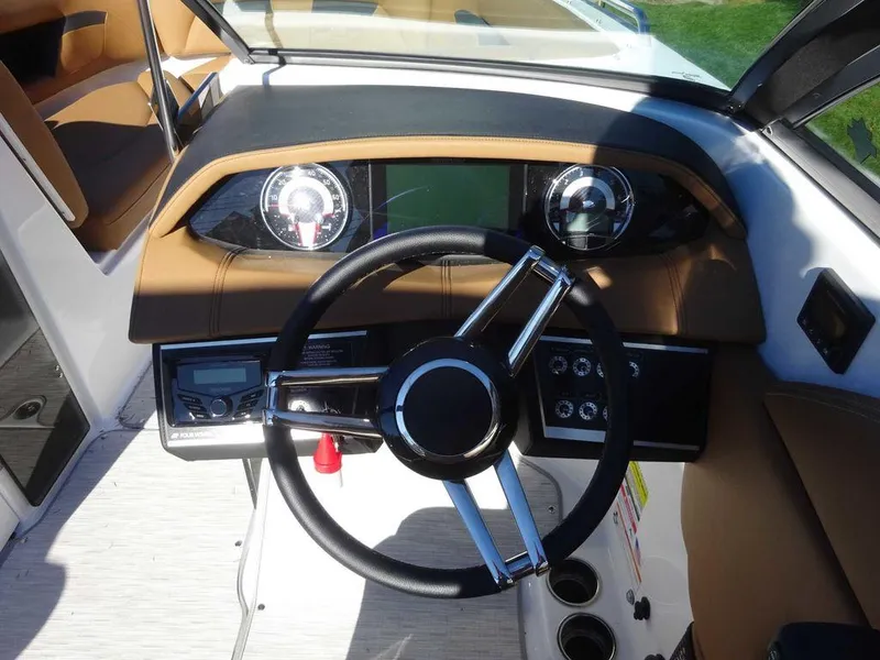 Slide: The Image of 2025 Four Winns HD 5 Sterndrive boat dashboard with steering wheel and gauges. - 13
