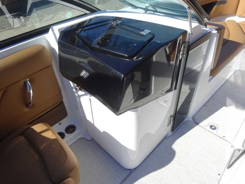 Slide: The Image of 2025 Four Winns HD 5 Sterndrive boat interior with sleek black console and tan seating. - 17