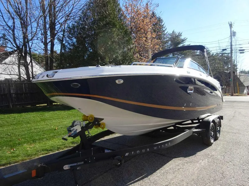 Slide: The Image of 2025 Four Winns HD 5 Sterndrive boat on trailer, parked on a sunny street. - 4