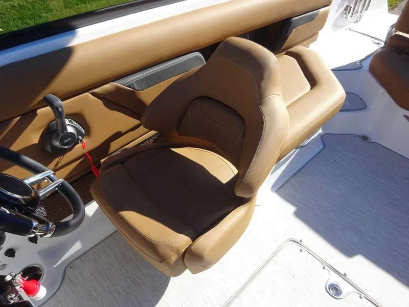 Slide: The Image of 2025 Four Winns HD 5 Sterndrive boat interior with tan seating and steering controls. - 7