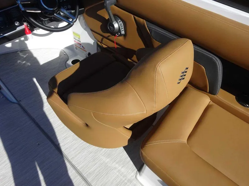 Slide: The Image of 2025 Four Winns HD 5 Sterndrive boat interior with tan leather seating and steering controls. - 8