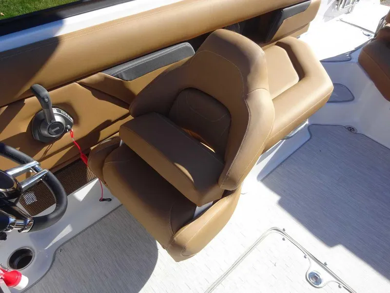 Slide: The Image of 2025 Four Winns HD 5 Sterndrive boat interior with tan seating and steering controls. - 9