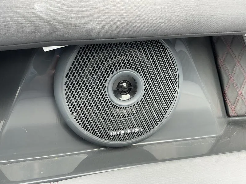 Slide: The Image of 2025 Cobalt R33 Surf boat interior with gray seating and red accents, docked by the water. - 9