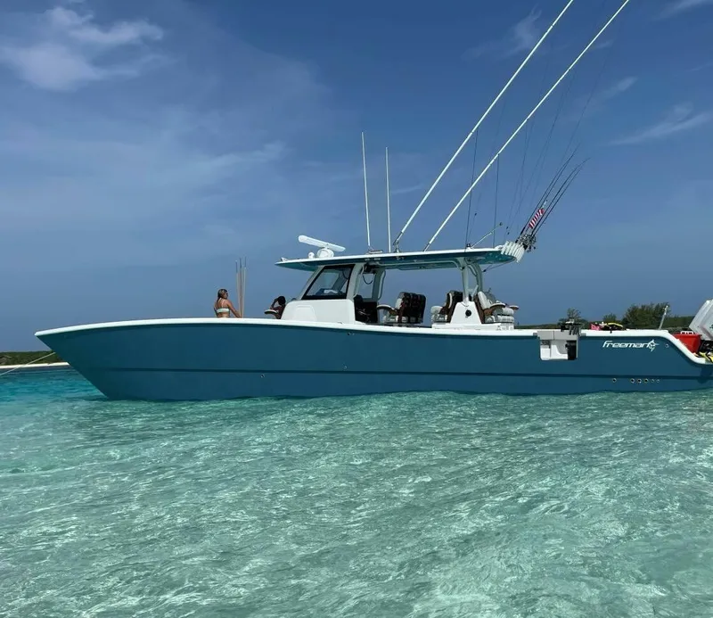 Slide: The Image of 2023 Freeman 47 boat in clear turquoise water under a blue sky. - 1