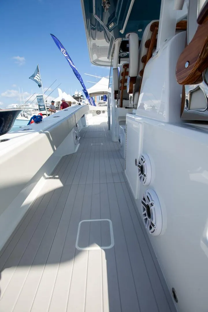 Slide: The Image of 2023 Freeman 47 boat deck with speakers and seating, showcased at a marina. - 18