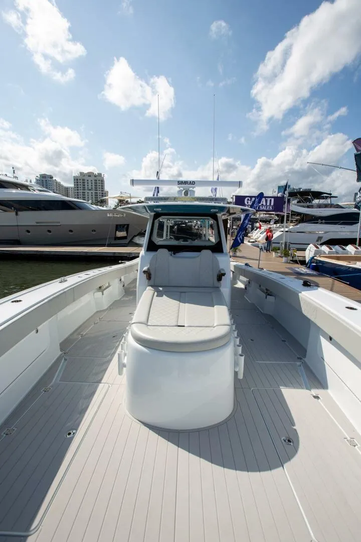 Slide: The Image of 2023 Freeman 47 boat at marina, clear sky, luxury yachts in background. - 22