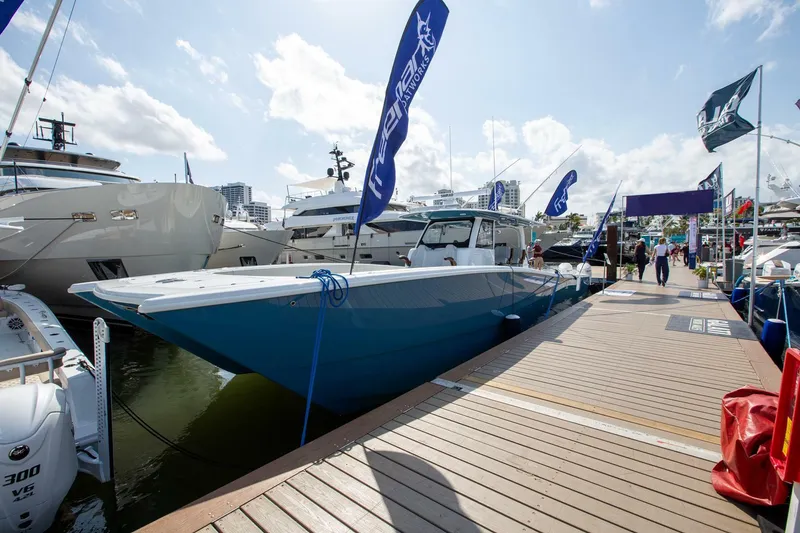 Slide: The Image of Freeman 47 boat docked at marina, 2023 model, with flags and clear sky. - 3