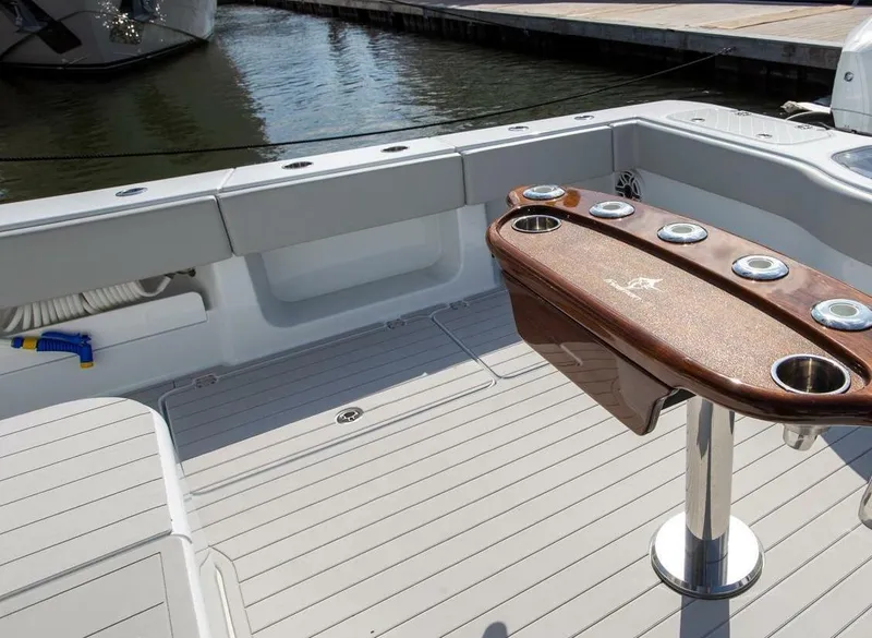 Slide: The Image of 2023 Freeman 47 boat deck with rod holders and seating area by the water. - 4