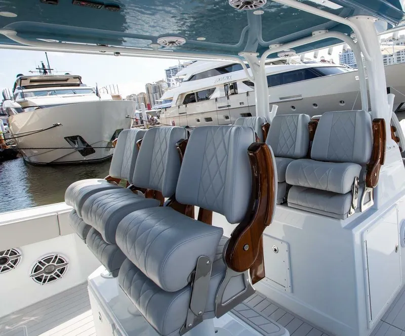 Slide: The Image of Luxury seating on a 2023 Freeman 47 boat, docked with yachts in the background. - 7