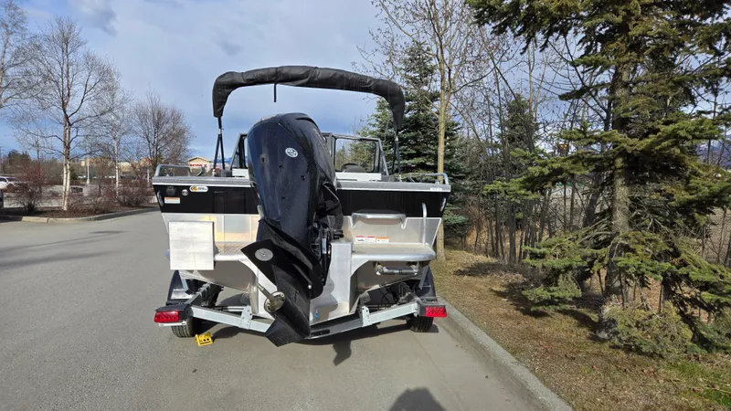 Slide: The Image of 2024 Spartan 185 Astoria boat with outboard motor on a trailer, parked on a road. - 4