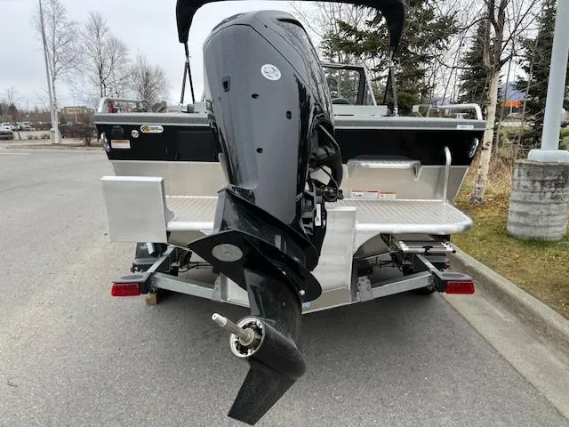 Slide: The Image of 2024 Spartan 185 Astoria boat with outboard motor on trailer, parked outdoors. - 5