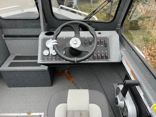 Slide: The Image of 2024 Spartan 185 Astoria boat cockpit with steering wheel and control panel. - 7