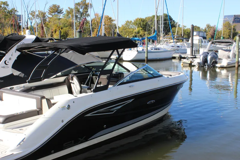 Slide: The Image of 2016 Sea Ray 250 SLX boat docked in a marina with other vessels. - 3