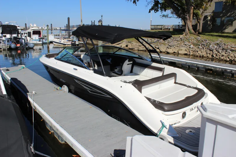 Slide: The Image of 2016 Sea Ray 250 SLX boat docked at marina with black canopy. - 8