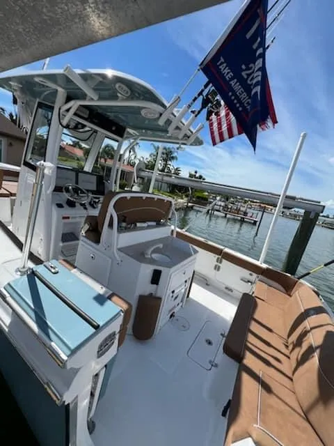 Slide: The Image of 2024 Sea Hunt Ultra 275 SE boat docked, featuring a spacious deck and modern amenities. - 12