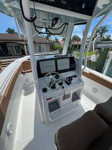 Slide: The Image of 2024 Sea Hunt Ultra 275 SE boat cockpit with dual displays and steering wheel. - 14