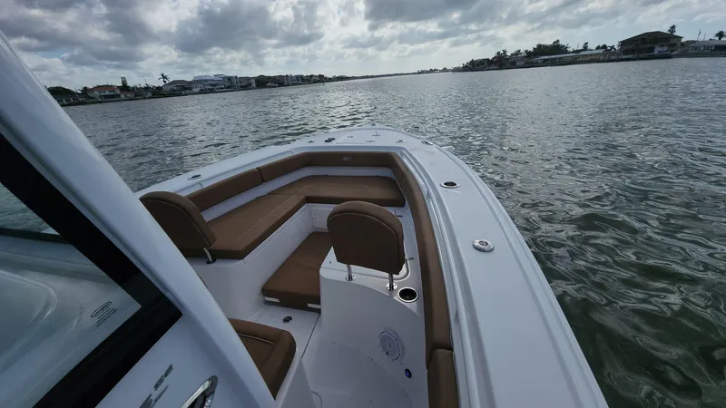 Slide: The Image of 2024 Sea Hunt Ultra 275 SE boat on calm water under cloudy sky. - 2