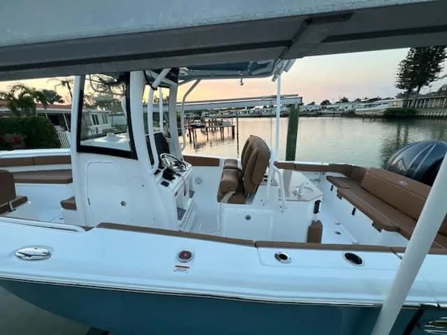 Slide: The Image of 2024 Sea Hunt Ultra 275 SE boat docked by serene waterfront. - 22